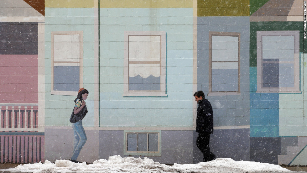 A pedestrian walks past a mural at the beginning of a winter storm in Somerville, Massachusetts, on Thursday, March 7.