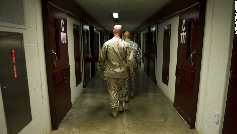 Members of the military walk the hallway of Cell Block C in the Camp 5 detention facility in January 2012. 