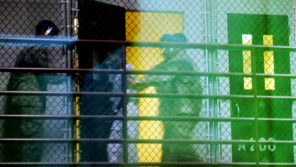 Guards move a detainee from his cell in Cell Block A of the Camp 6 detention facility in January 2012. 