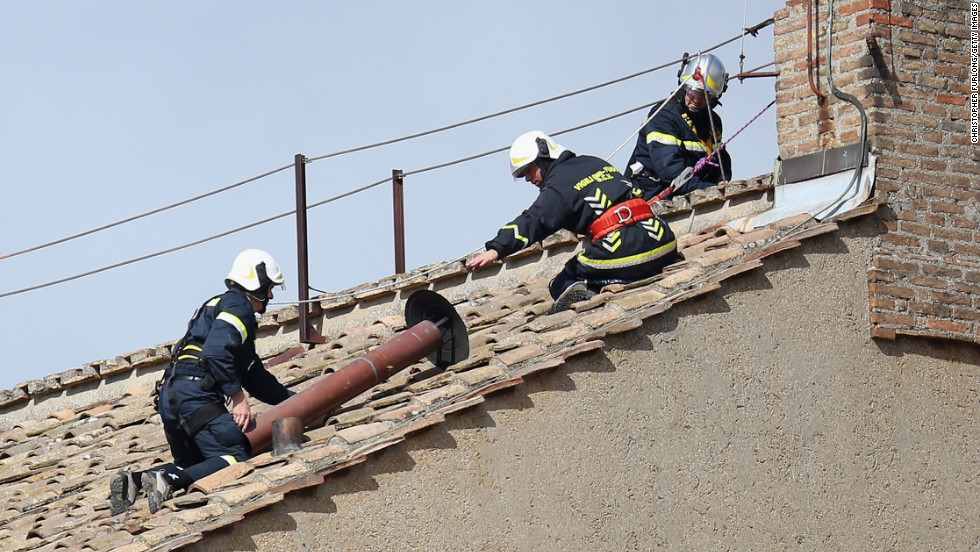 Members of the Vatican Fire Brigade install the chimney on top of the Sistine Chapel on March 9.