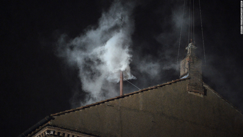 White smoke rises from the chimney on the roof of the Sistine Chapel.