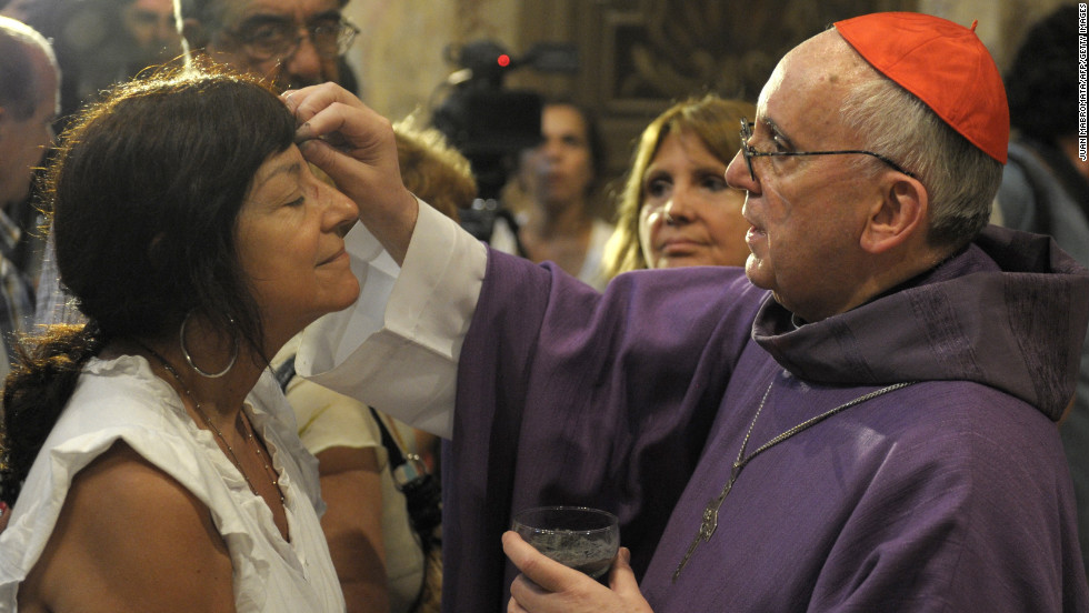 Bergoglio, right, draws the cross on the forehead of a parishioner during a Mass for Ash Wednesday, which begins the 40-day period of abstinence for  Christians before the Holy Week and Easter, on February 13 at the Metropolitan Cathedral in Buenos Aires.
