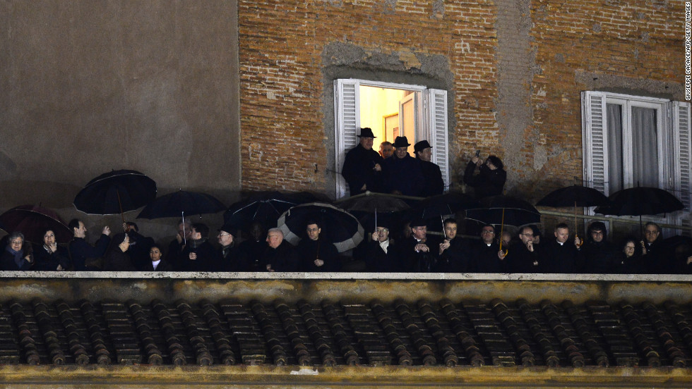 People stand on a balcony at St. Peter&#39;s Square as they wait for the identity of the new pope to be revealed.