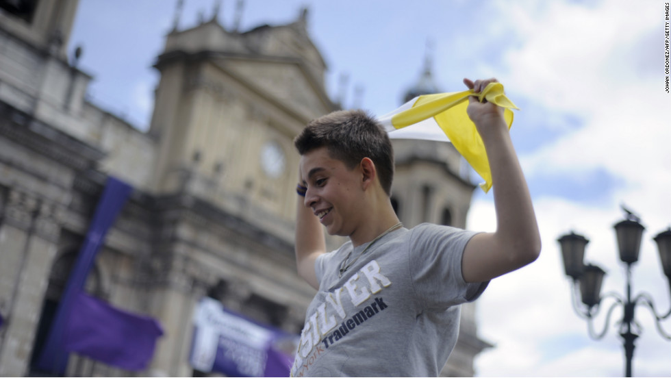 A young man waves a flag of the Vatican after the announcement of the election of Argentina&#39;s cardinal Jorge Bergoglio, as Pope Francis in Guatemala City.