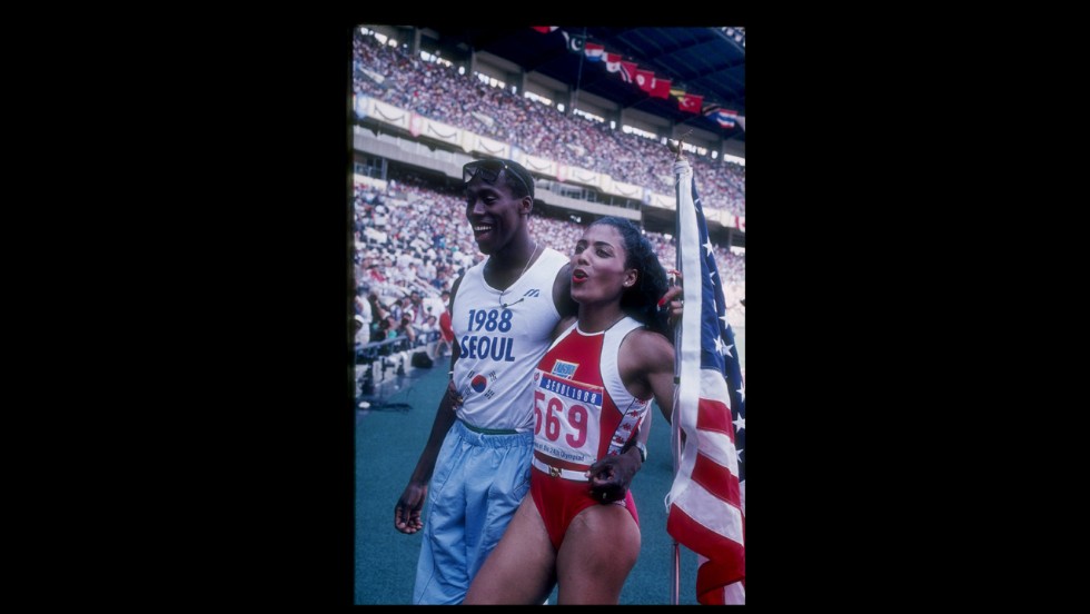 Florence Griffith-Joyner, known as Flo Jo, and Al Joyner, Olympic gold medal winning triple jumper and Flo Jo&#39;s coach, met at the U.S. Olympic trial in 1980 and married in 1987. Flo Jo won golds in both the 100 meter and 200 meter at the Seoul Olympics in the following year. She died in 1998. Pictured, she walks off the track with her husband Al Joyner during the Olympic Games in Seoul, South Korea, 1988.