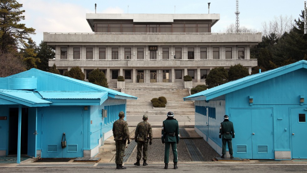 South Korean soldiers stand guard as a North Korean soldier, far center, looks on at the truce village of Panmunjom in the demilitarized zone dividing the two Koreas on March 13.