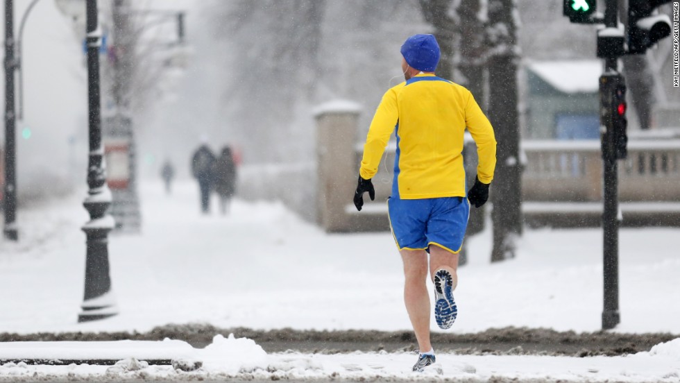 A jogger runs across a snow-covered street in Berlin on March 19.