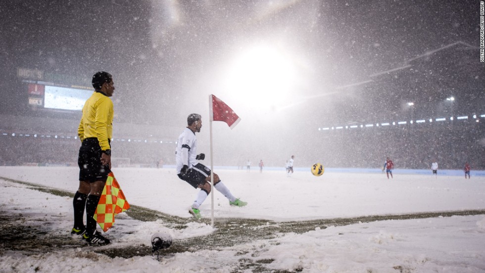 American striker Herculez Gomez takes a corner from one of the few spots of the pitch not covered in snow.