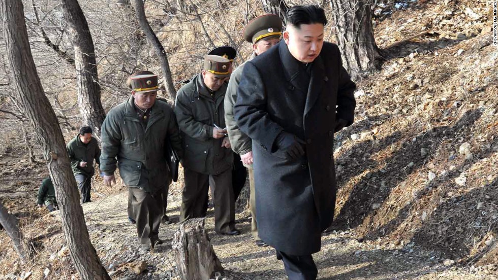 Kim, with North Korean soldiers, makes his way to an observation post in March 2013.