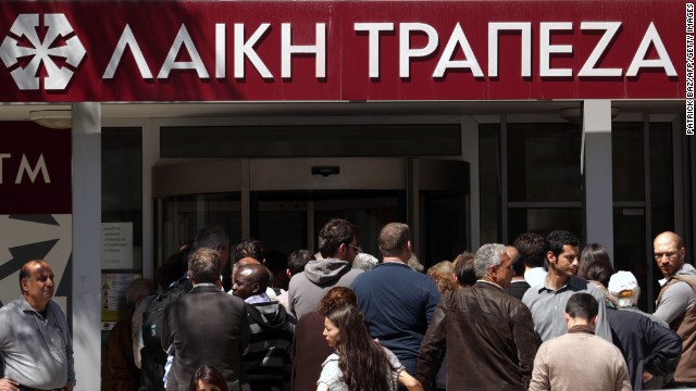People queue up outside a Laiki bank branch in the Cypriot capital, Nicosia, on March 28, 2013, as they wait for the bank to open after an unprecedented 12-day lockdown. Queues of dozens of people formed before the doors swung open at 12:00pm (1000 GMT) for the first time since March 16, and there were tensions as a few branches opened late, with customers banging on the doors. AFP PHOTO / PATRICK BAZ        (Photo credit should read PATRICK BAZ/AFP/Getty Images)
