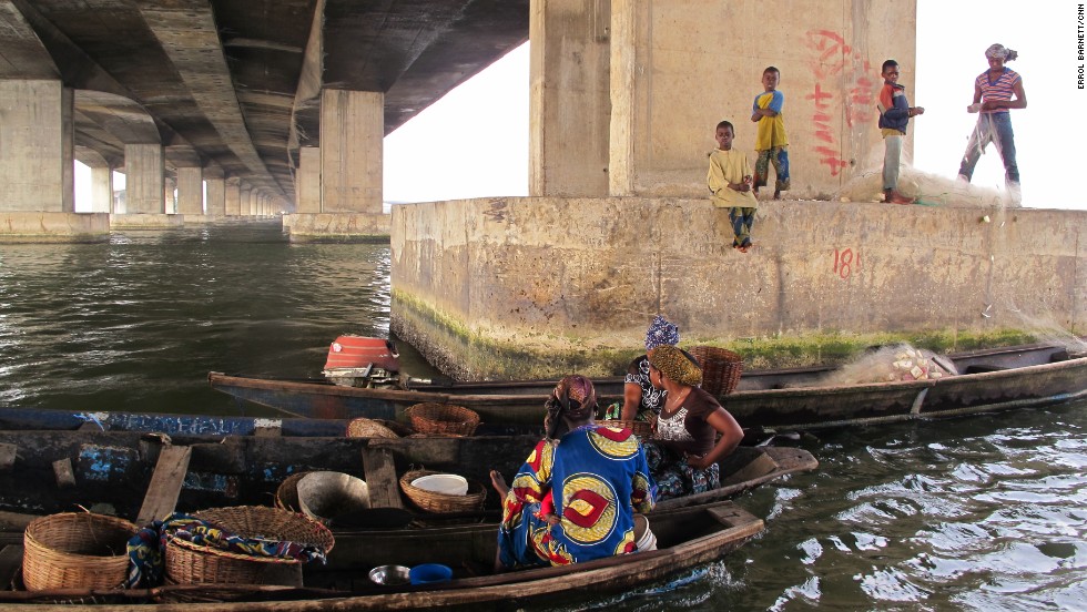 Women and children congregate under the Third Mainland Bridge, which connects Lagos Island with Nigeria&#39;s mainland. Many who live in Lagos and cross the bridge have never been to Makoko. 