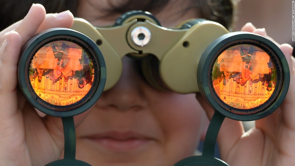 An attendee looks at St. Peter&#39;s Basilica through binoculars on Sunday.