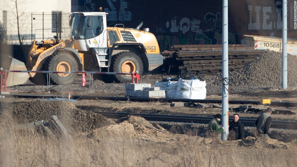 Experts from the bomb disposal team and a police officer stand in a pit next to railway tracks. Some train services were delayed, said a spokesman for German railway operator Deutsche Bahn. 