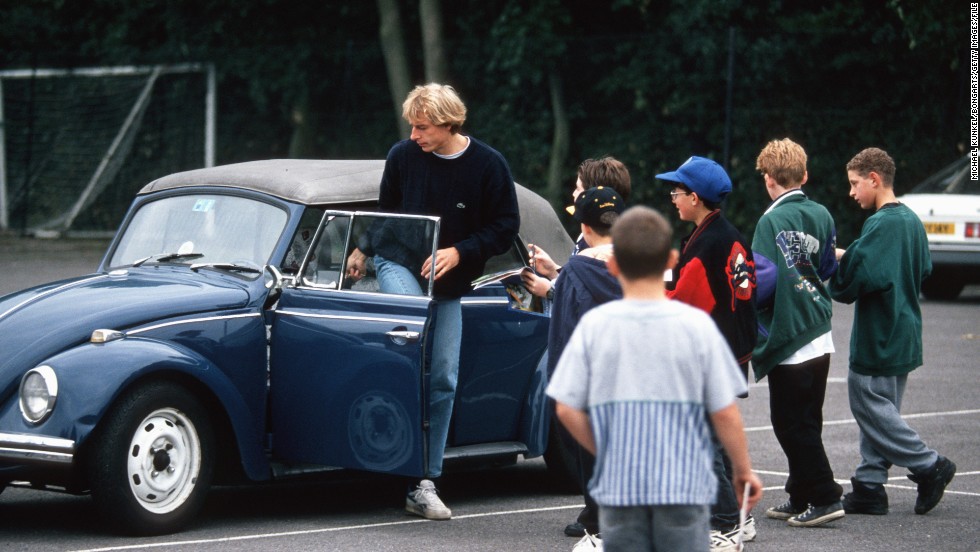 Former Germany star and current U.S. coach Jurgen Klinsmann gets into his Volkswagen Beetle while surrounded by onlooking schoolchildren.
