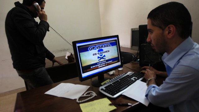 Palestinians look at a picture depicting the &#39;#Op_Israel&#39; campaign launched by Anonymous in Gaza City on Sunday.