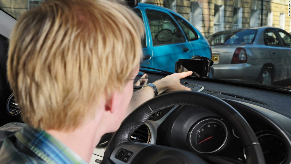 OK, you probably shouldn&#39;t be like this guy and play with your phone when driving. But the upcoming Moto X phone at least makes it a little safer. The Moto X lets you speak voice commands to your phone without touching it and will read your text messages aloud.