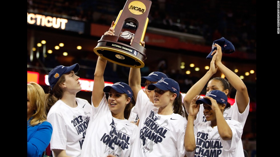 UCONN players hold up the National Championship trophy with their teammates after defeating the Louisville Cardinals on April 9.