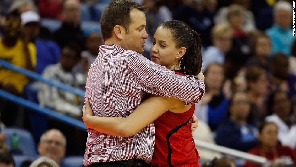 Head coach Jeff Walz of Louisville hugs Shoni Schimmel as she exits the game near the end of regulation against the Connecticut Huskies on April 9.