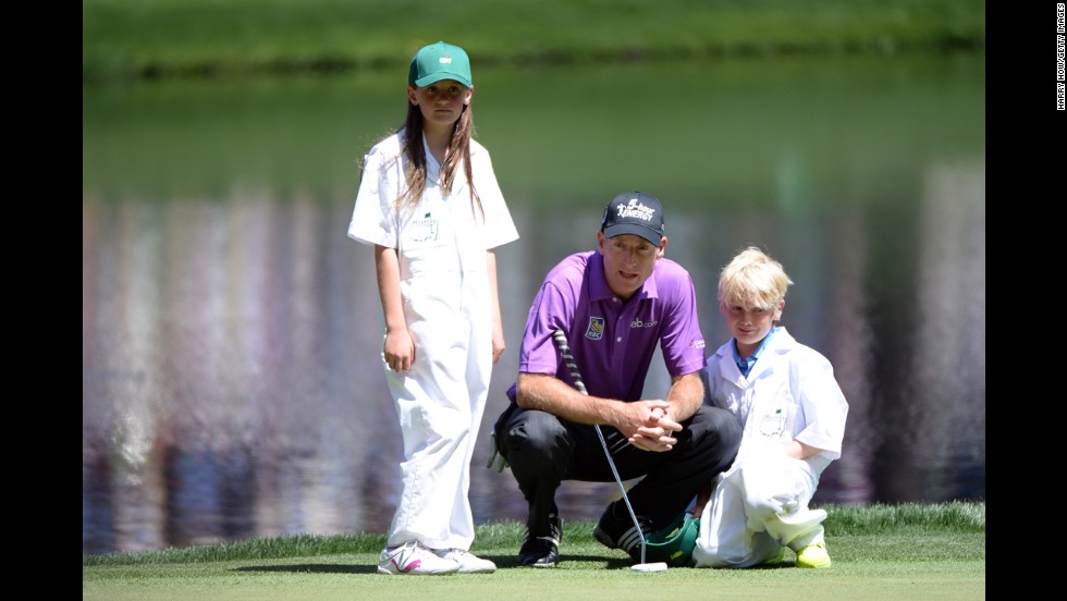 Jim Furyk of the U.S. lines up a putt with his children Caleigh and Tanner.