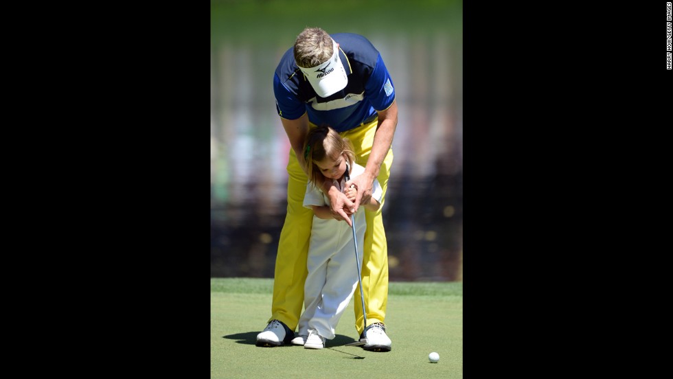 Luke Donald of England putts with his daughter Elle.