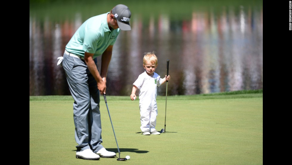 John Merrick of the U.S. putts as his son, Chase, watches.
