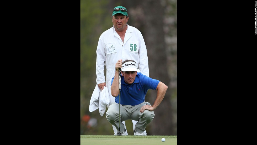Gonzalo Fernandez-Castano of Spain lines up a putt as his caddie, Jeffrey Paul, looks on from the third green.
