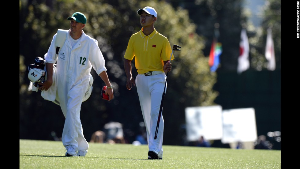 Guan Tianlang of China walks with his caddie during the third round.