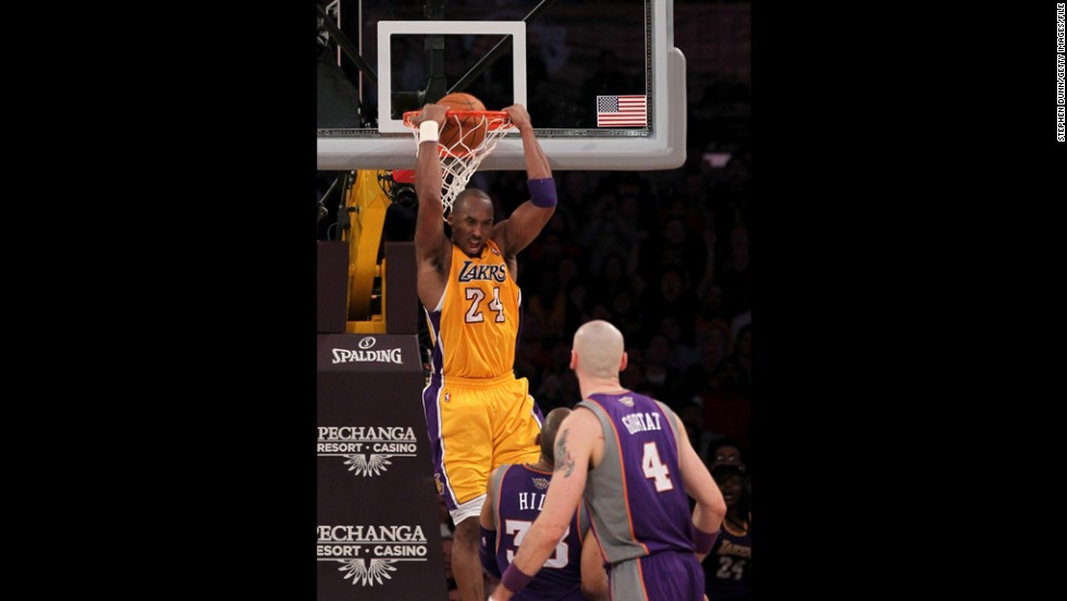 Bryant reverse dunks over Grant Hill, No. 33, and Marcin Gortat, No. 4, of the Phoenix Suns at Staples Center on January 10, 2012, in Los Angeles. The Lakers won 99-83.