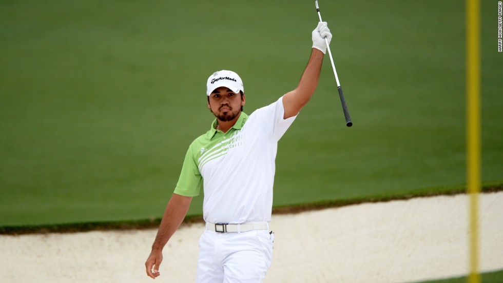 Jason Day of Australia lifts his club after hitting the ball out of the bunker for an eagle on the second hole.