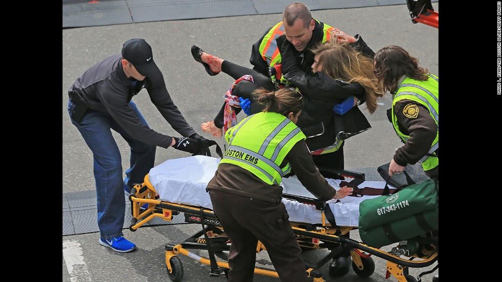 An injured woman is placed on a stretcher. 