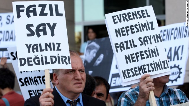 A poster reads &quot;Fazil Say is not alone,&quot; left, at a protest outside an Istanbul court on October 18, 2012. 