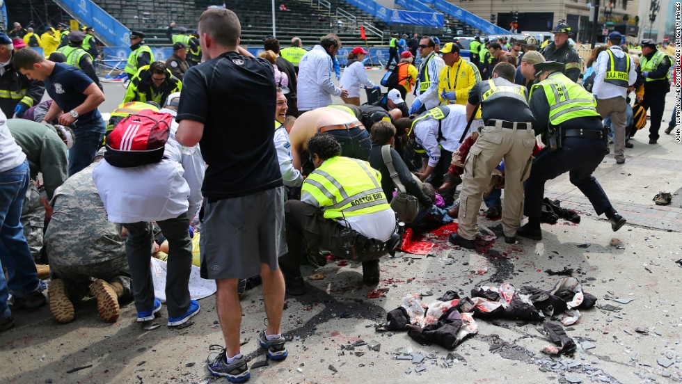 Victims are helped at the scene of the first explosion.