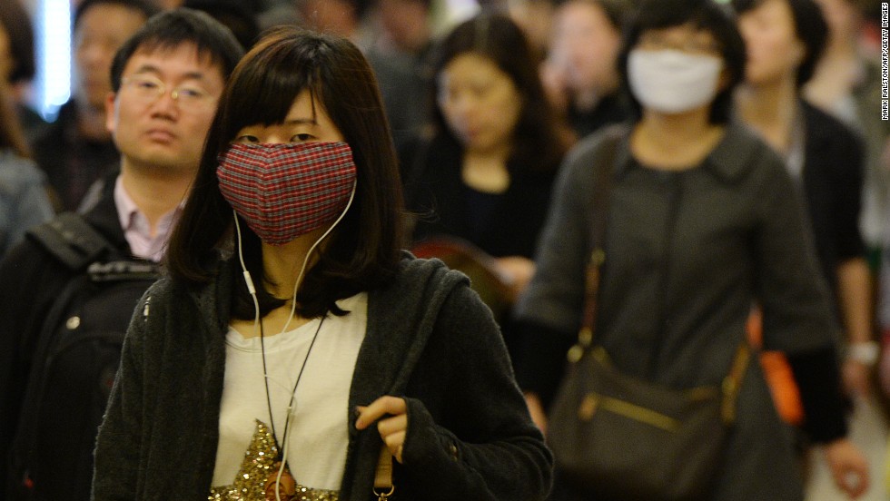 Women wear facemasks as the city's commuters protect themselves against the H7N9 bird flu virus in the downtown area of Shanghai in 2013.