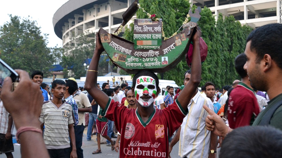 Outside of Saltlake Stadium, a fan wears the Mohun Bagan A.C. shirt and celebrates the last match of Brazilian player Jose Ramirez Barreto. Thousands of Barreto fans arrived to express their adoration, despite the fact that the revered footballer was simply switching teams and not leaving the game altogether.