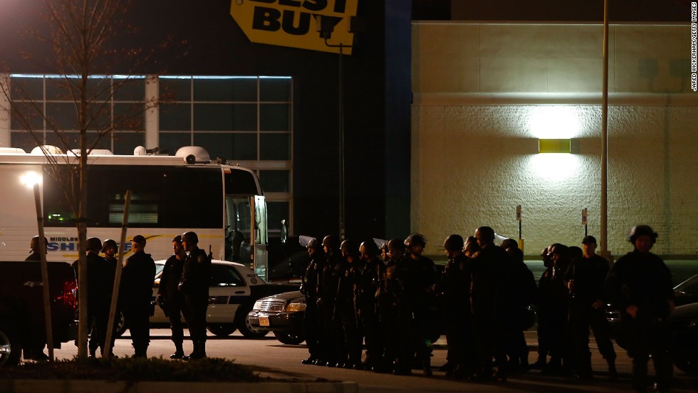 Boston Police gather in the parking lot in front of a Best Buy store near the Watertown Mall on Friday.