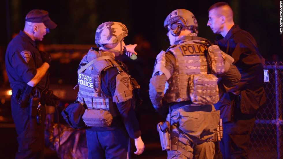 Police search neighborhoods yard by yard on Friday.