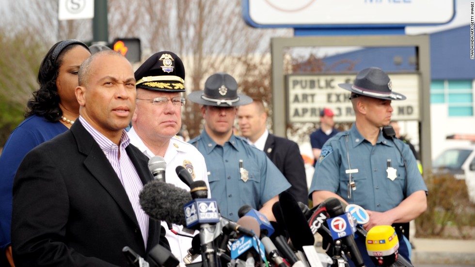 Massachusetts Gov. Deval Patrick, left,  speaks to the media at a shopping mall on the perimeter of a locked-down area during the search on Friday.