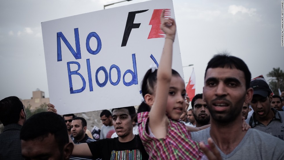 A Bahraini protestor holds up a poster against the country&#39;s upcoming Formula One Grand Prix during a demonstration in the village of Jid Ali, north-east of Isa Town. Protesters in Bahrain plan to step up demands for reform ahead of Sunday&#39;s race.