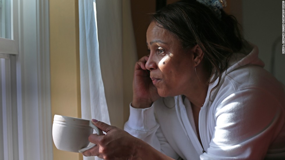 Katia Costa looks out her window as police continue the manhunt on Nichols Avenue in Watertown on Friday.