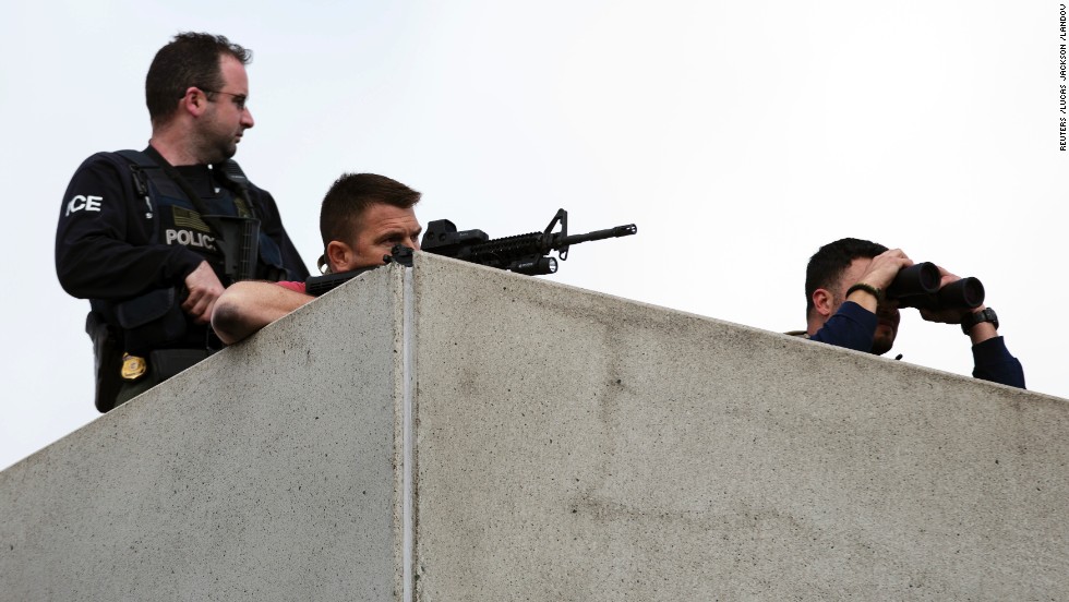 Law enforcement officers place themselves in an overhead position on Arsenal Street as the search continues on April 19.