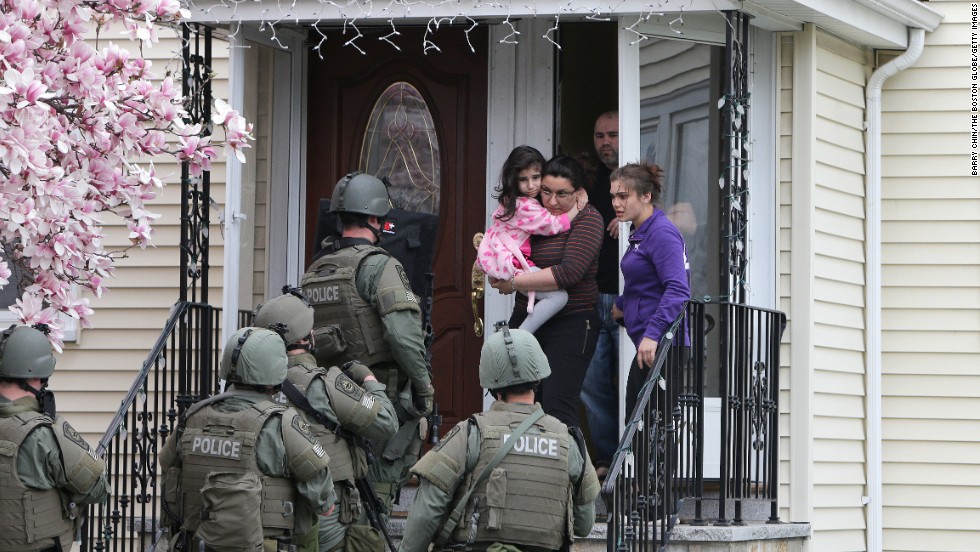 SWAT teams prepare to enter a home as they continue the door-to-door search.