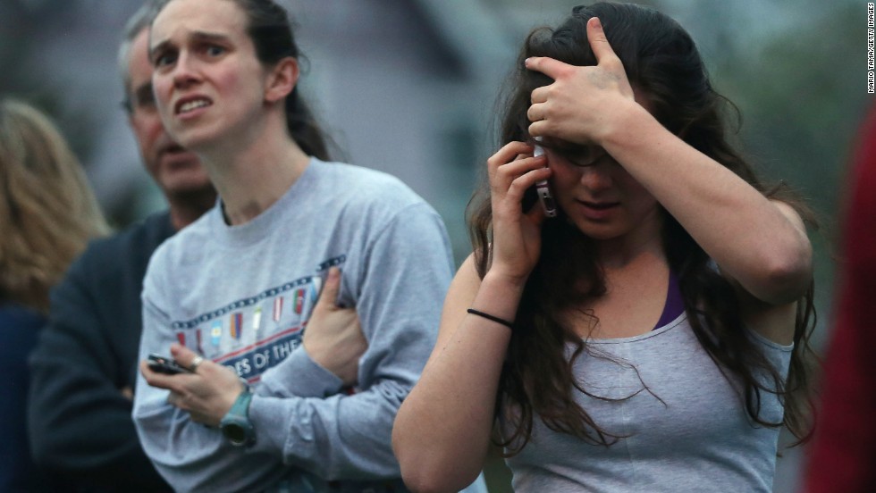 People react while watching police respond to reported gunfire on April 19.