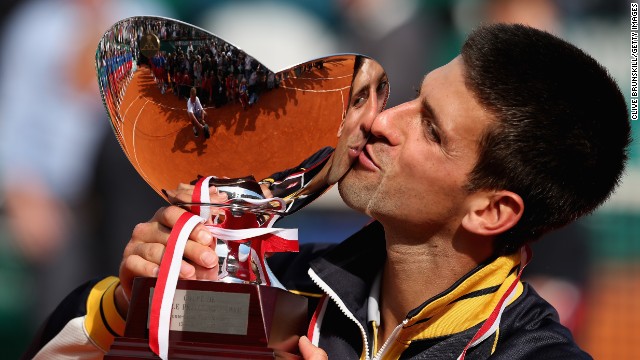 Serbian tennis star Novak Djokovic kisses the trophy after his straight-sets victory against defending champion Rafael Nadal.