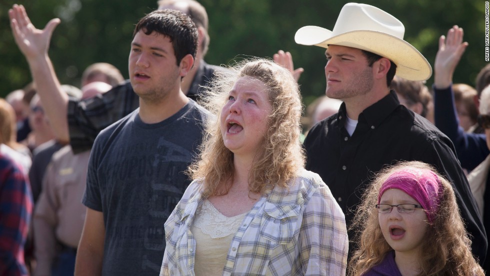 Vanna Wainwright and her daughter Breanna take part in an open air Sunday service on April 21. Members of the First Baptist Church held their service in an open air field after their church was damaged from the explosion. 