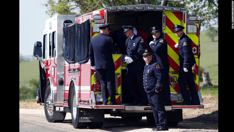 Firefighters stand on the back of a firetruck that transported Harris&#39; body to the Bold Springs Cemetery in West on April 24.