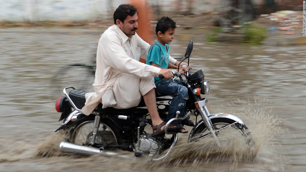 A Pakistani motorcyclist crosses a flooded street after heavy rain in Peshawar on April 26. Pakistan has suffered devastating monsoon floods for the last three years, including the worst in its history in 2010, when catastrophic inundations killed almost 1,800 people and affected 21 million. 
