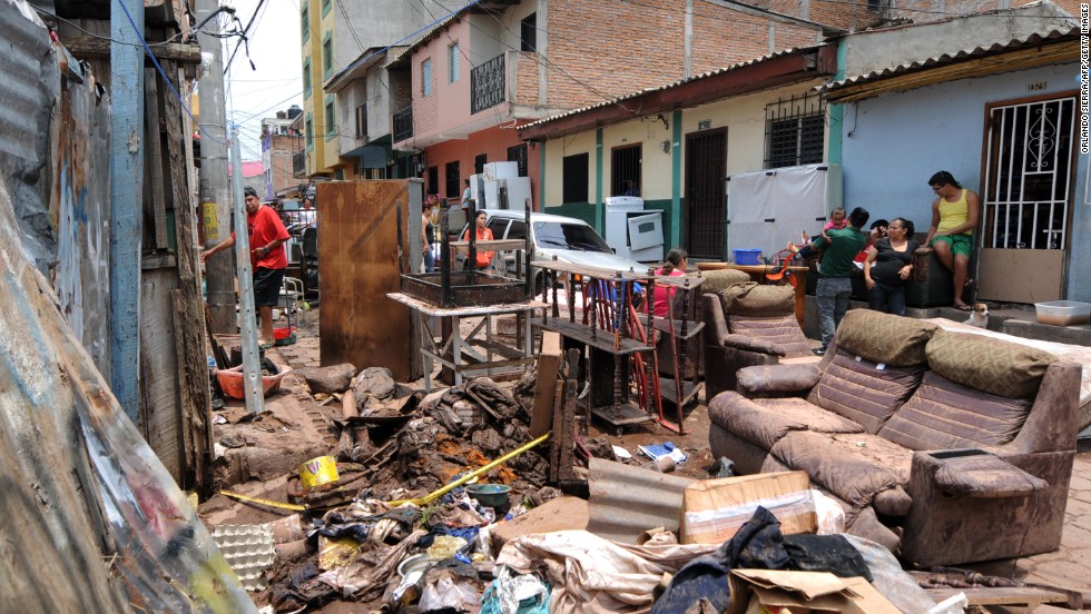 People in the Morazan neighborhood of Tegucigalpa, Honduras, sort through the remains of their possessions after heavy rains left two people missing and destroyed streets and homes.
