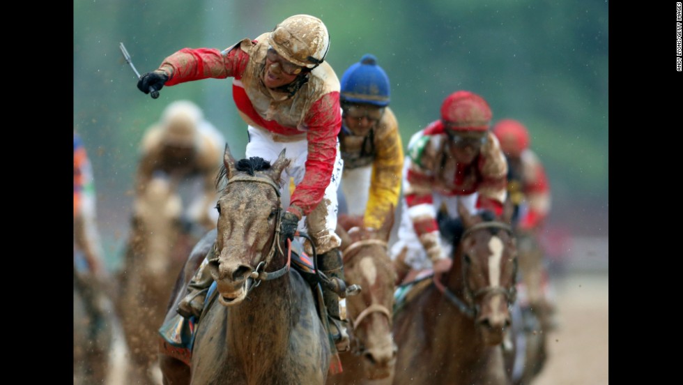 Rosario rejoices atop a mud-splattered Orb after winning the race.