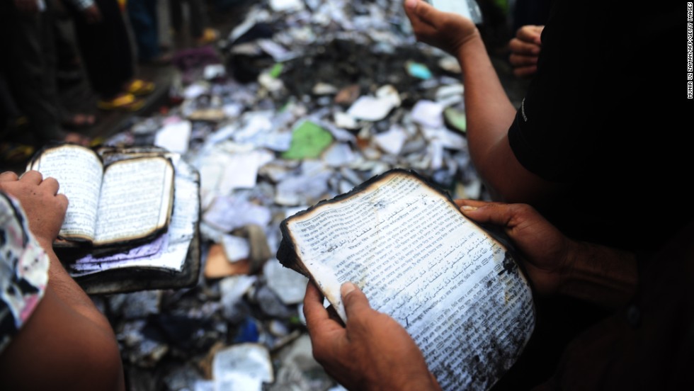 Bangladeshi people look at burned religious literature, including the Quran, near the national mosque Baitul Mukarram in Dhaka on May 6.