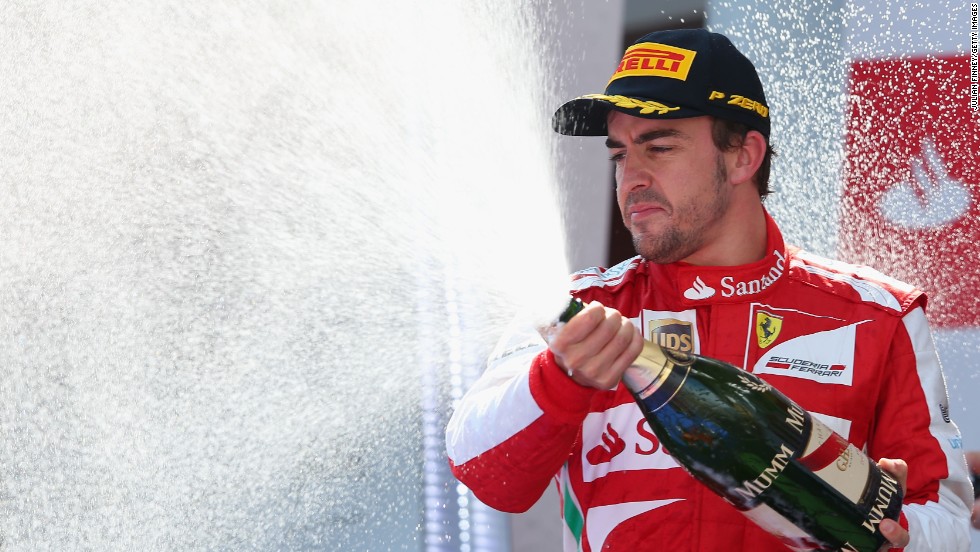 Fernando Alonso celebrates on the podium after winning the Spanish Grand Prix.